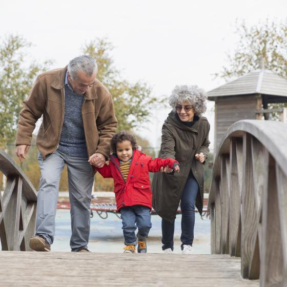 child crosses bridge with grandparents
