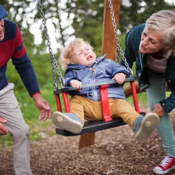 parents and kids on park swings