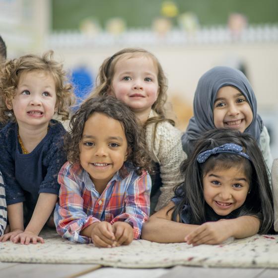 multi-racial pre-school kids gathered on mat